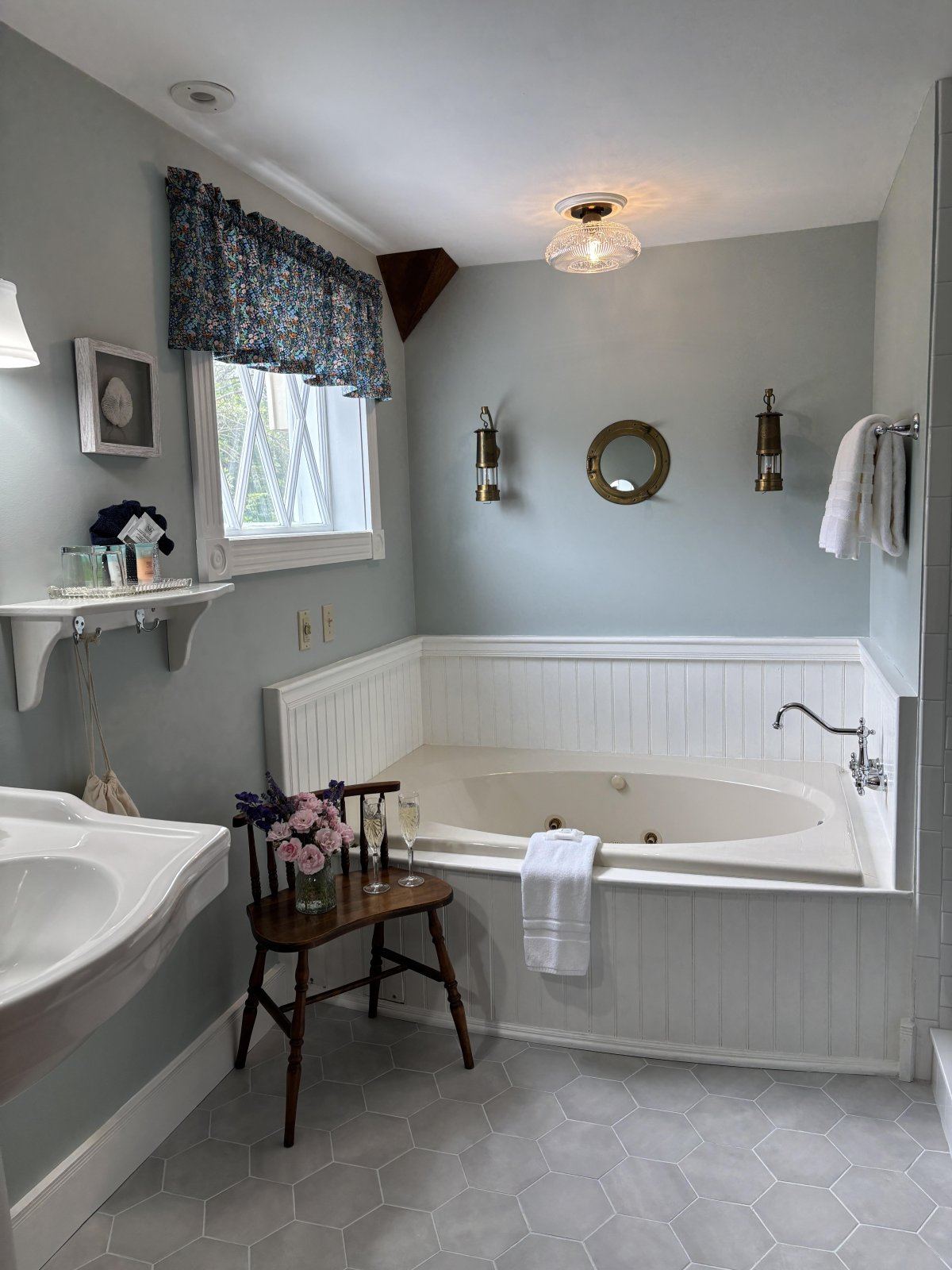 Captain's Quarters bathroom: jetted tub with hexagonal tile and shell artwork