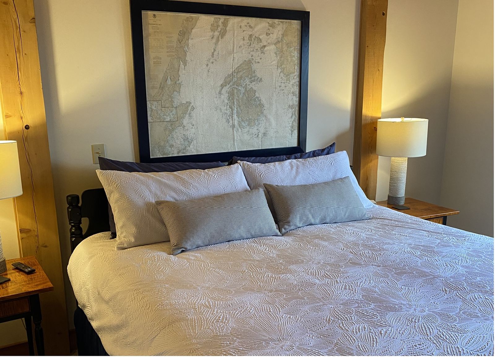 Chart Room: a framed Penobscot Bay chart above the bed, white bedding and striped pillows
