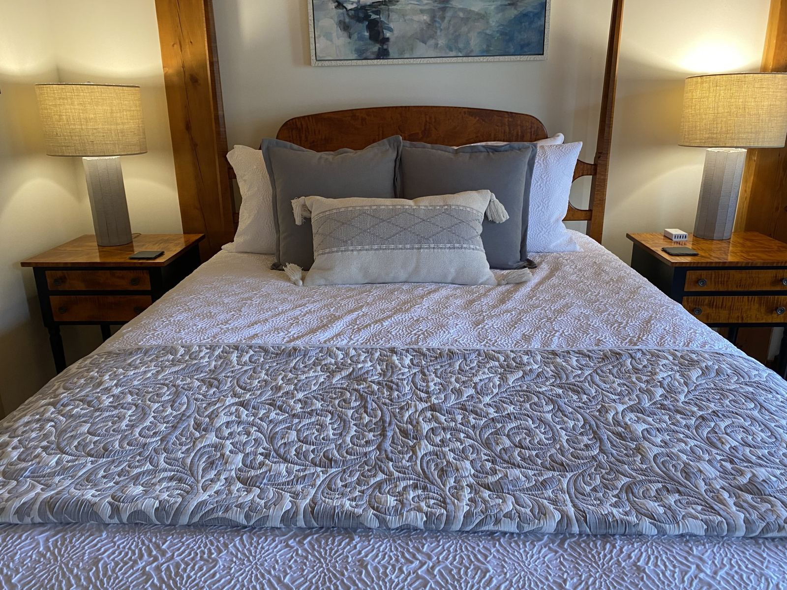 Helmsman's Quarters: four-poster bed in calm grey-blue bedding with tassel pillows and fabric lamps